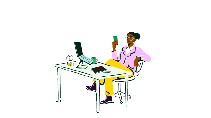 a person sitting at a desk with a laptop and a phone